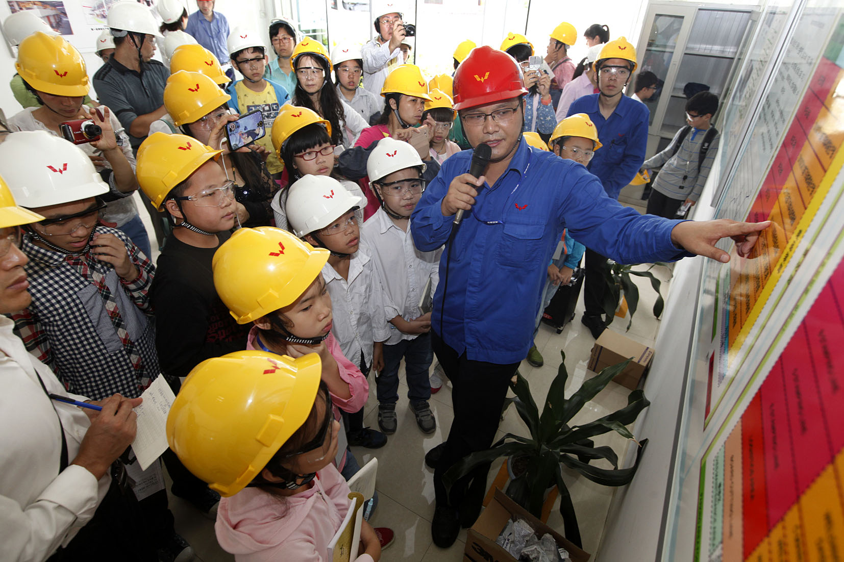 3868la银河总站员工向幼记者们介绍冲焊件厂发展情况